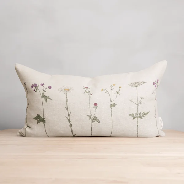 Beige kudde i 100 % linne med blommor som mönster, tillverkad av NORDRÅ Sweden som säljer presenter och inredning.