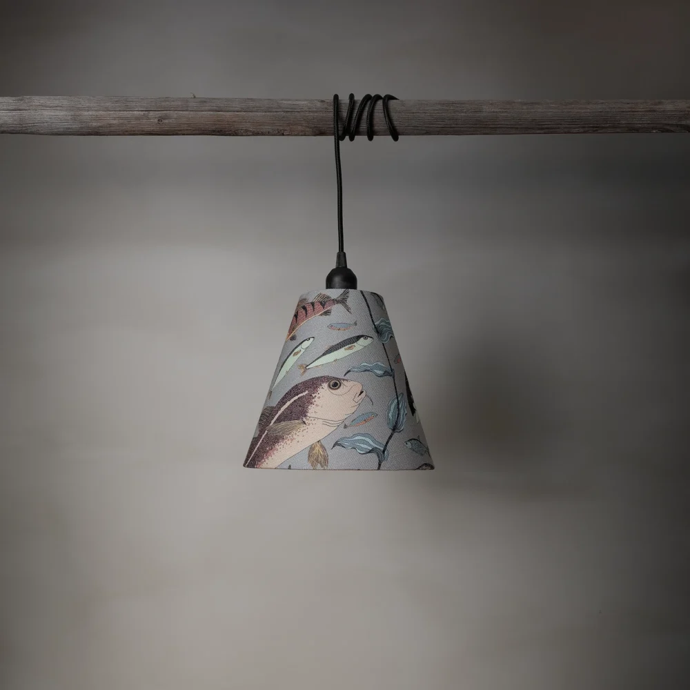 Lampskärm i linneblandning med ett mönster av fiskar, tillverkad av NORDRÅ Sweden som säljer presenter och inredning.