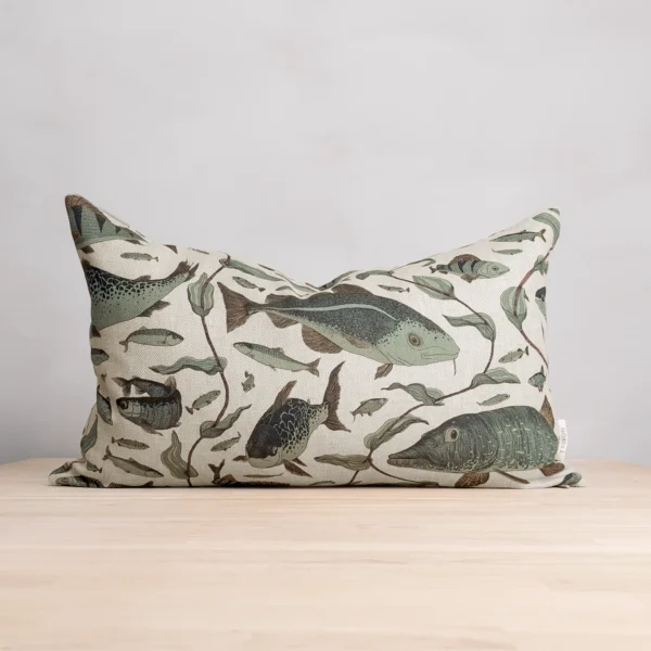 Grön och beige kudde i linne med fiskar som mönster, tillverkad av NORDRÅ Sweden som säljer presenter och inredning.