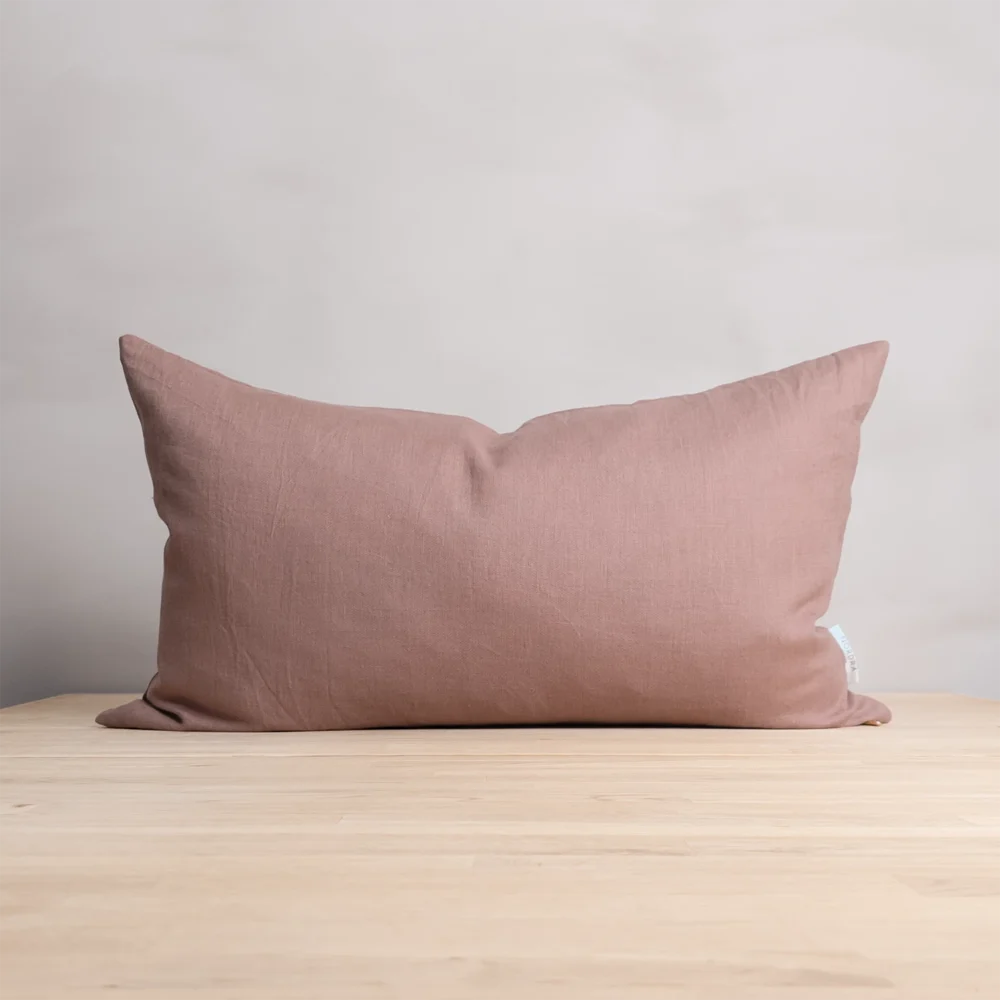 Enfärgat rosa kuddfodral i 100 % linne, tillverkad av NORDRÅ Sweden som säljer presenter och inredning.