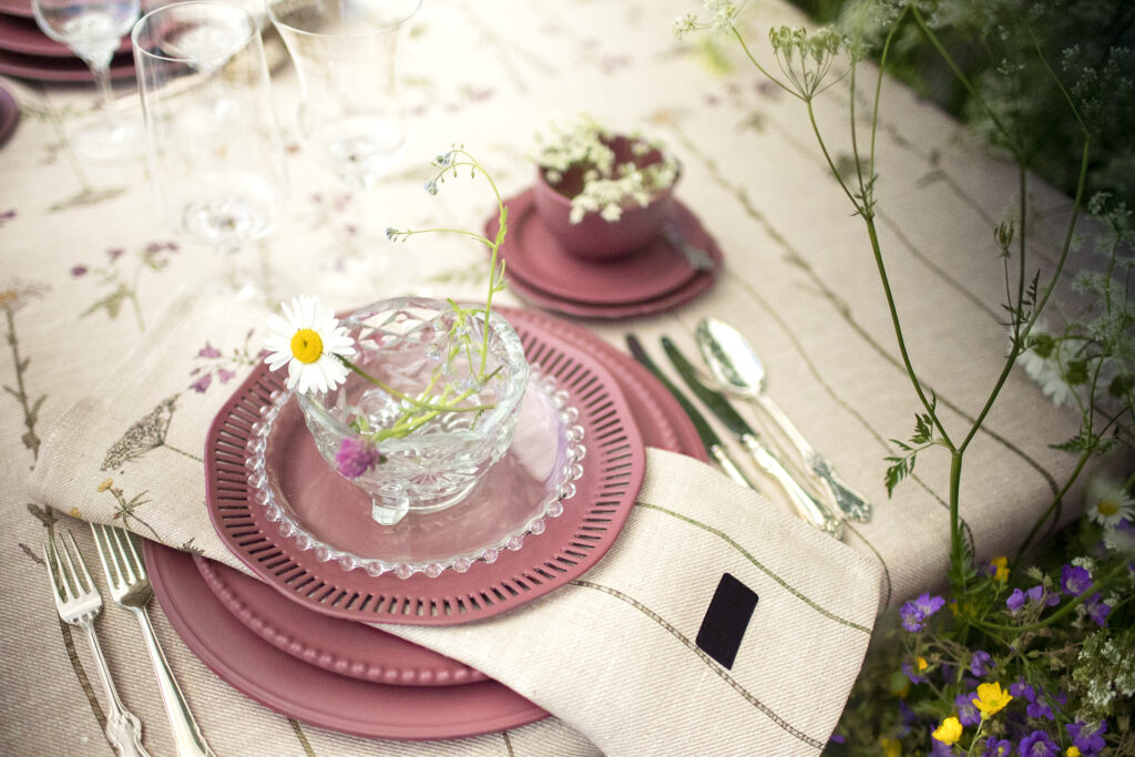 Midsommardukning med blommig linneduk och servetter från NORDRÅ Sweden med rosa servis