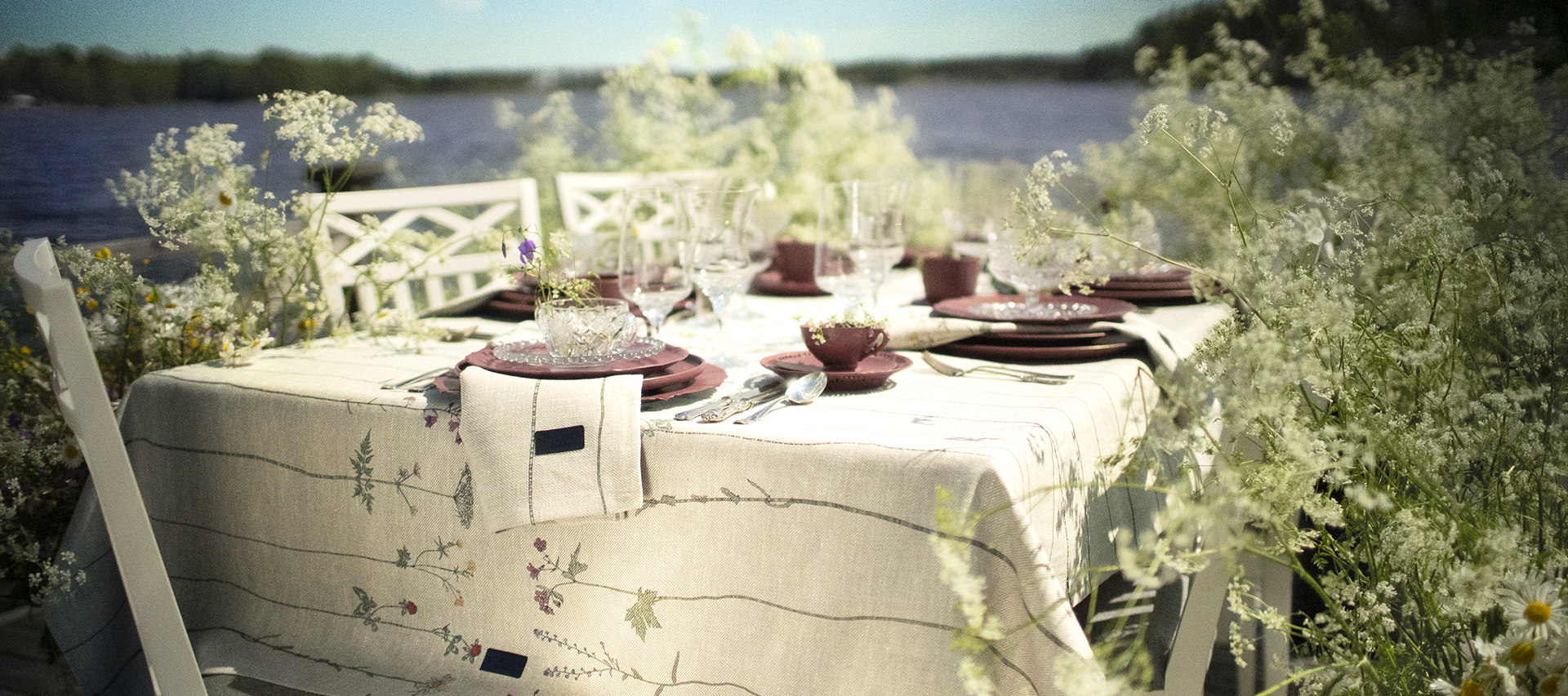 Midsommardukning med bordsduk och servetter i linne med unik mönsterdesign SommarBlomster i färgen LinKalk från nordrå Sweden. Svensk inredning och presenter.